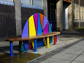 Brightly coloured metal and wood seat